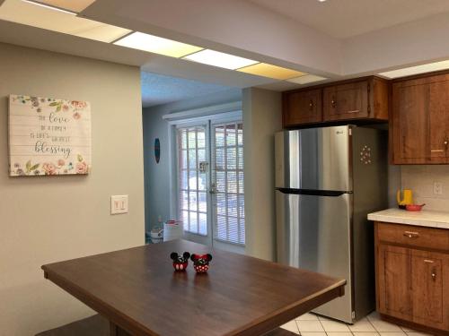 a kitchen with a table and a stainless steel refrigerator at Flamingo Heated Pool House in Palm Coast