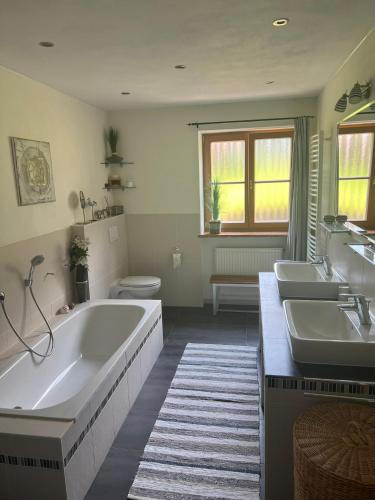 a bathroom with two sinks and a tub and a toilet at Ferienhaus Malterlehen in Marktschellenberg
