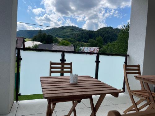 a wooden table and chairs on a balcony with a view at Ubytovanie na Pánskej in Terchová