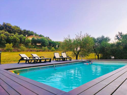 a swimming pool with two lounge chairs next to it at House La Torricella in Vetriolo