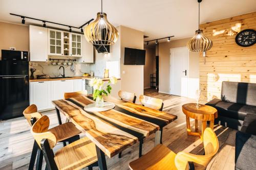 a kitchen and living room with a wooden table and chairs at Zawoja House in Zawoja