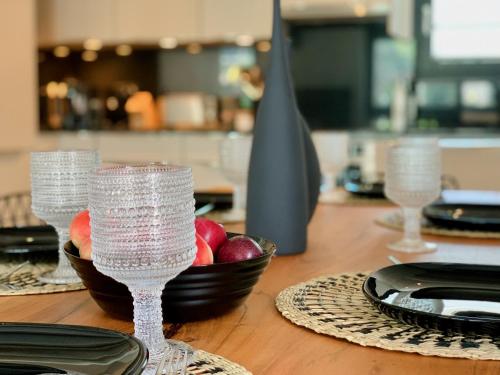 a wooden table with glasses and a bowl of fruit at Dora o wellness o mountainview o lake Lucerne in Ingenbohl