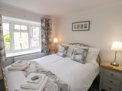 Un dormitorio con una cama blanca con toallas. en Braeside, en Richmond