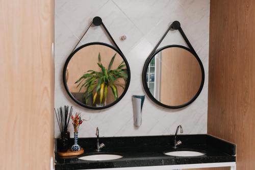 a bathroom with two sinks and two mirrors on the wall at Via Brasil Hotel in São Luís
