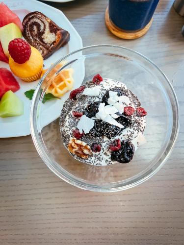 a glass bowl with a dessert with fruit and powdered sugar at Domicil Hotel Bonn in Bonn