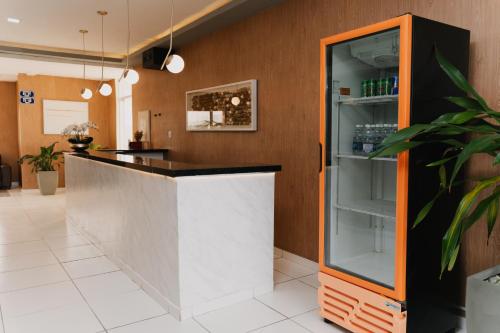 un bar con un bancone arancione e bianco di Via Brasil Hotel a São Luís