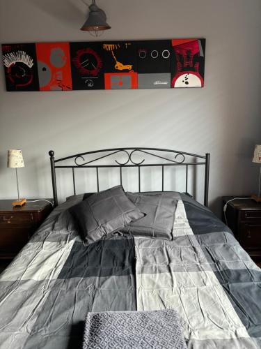 a bedroom with a bed with gray sheets and pillows at ARTgroturystyka Przystanek Błotna in Ostrów Podlaski