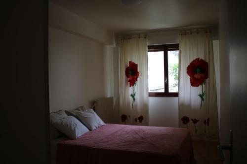 - une chambre avec un lit et une fenêtre fleurie dans l'établissement Chez Toni, à Asnières-sur-Seine
