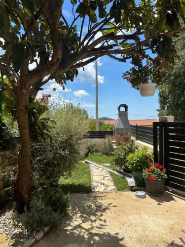 a garden with a tree and some plants and a fence at Apartment Mare in Poreč