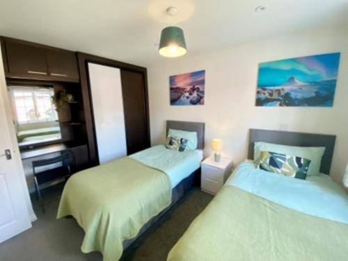 a bedroom with two beds and a television in it at Guest Favourite - Home from Home in Cosford