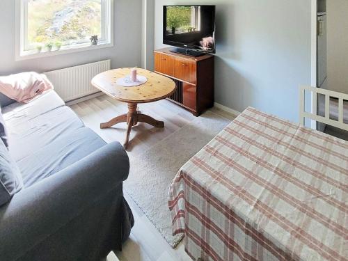 a living room with a couch and a table and a tv at 4 person holiday home in Nösund in Nösund