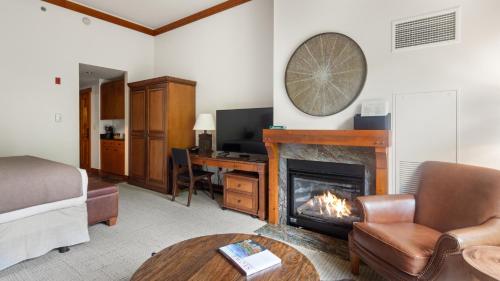 a living room with a fireplace and a couch at 1117 Lodge At Spruce Peak Ski In Ski In Ski Out King Studio By Stowe Mountain Rentals in Stowe