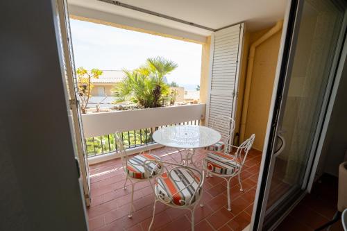 un balcon avec une table et des chaises sur un balcon dans l'établissement Superbe T3 pour 6 personnes, résidence calme avec piscine, à Cassis
