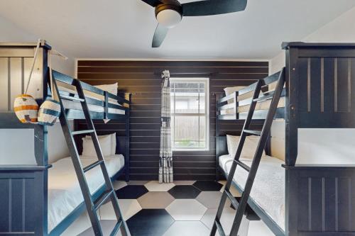 a bunk room with two bunk beds and a ceiling at Toes In The Sand in Port Aransas
