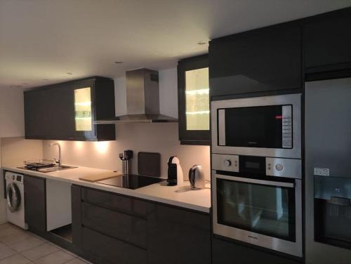 La cuisine est équipée d'un four micro-ondes et d'un évier. dans l'établissement Magnifique maison avec extérieur, à Aulnay-sur-Mauldre