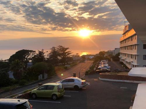 a parking lot with cars parked in front of a building at Little Penguin in Simonʼs Town