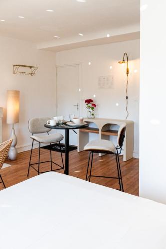 a kitchen and dining room with a table and chairs at Villa Robs - Appartements tout confort, TV connectée, Haut débit, Localisation idéale - Courts séjours & Affaires in Caen