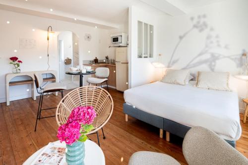 a bedroom with a bed and a table with flowers at Villa Robs - Appartements tout confort, TV connectée, Haut débit, Localisation idéale - Courts séjours & Affaires in Caen