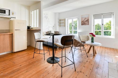 a kitchen with a table and chairs in a room at Villa Robs - Appartements tout confort, TV connectée, Haut débit, Localisation idéale - Courts séjours & Affaires in Caen