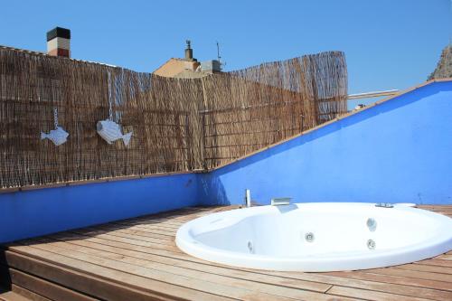 a bath tub sitting on top of a wooden deck at Hotel Marisqueria Cal Tet in L'Estartit