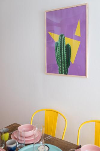 a dining room table with yellow chairs and a cactus at Villa Robs - Appartements tout confort, TV connectée, Haut débit, Localisation idéale - Courts séjours & Affaires in Caen