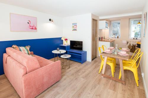 a living room with a couch and a table at Villa Robs - Appartements tout confort, TV connectée, Haut débit, Localisation idéale - Courts séjours & Affaires in Caen