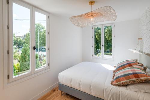 a bedroom with white walls and windows and a bed at Villa Robs - Appartements tout confort, TV connectée, Haut débit, Localisation idéale - Courts séjours & Affaires in Caen