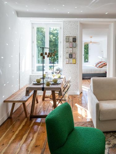 a living room with a table and a green chair at Villa Robs - Appartements tout confort, TV connectée, Haut débit, Localisation idéale - Courts séjours & Affaires in Caen