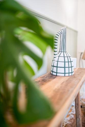 a blue and white vase sitting on a wooden table at Villa Robs - Appartements tout confort, TV connectée, Haut débit, Localisation idéale - Courts séjours & Affaires in Caen