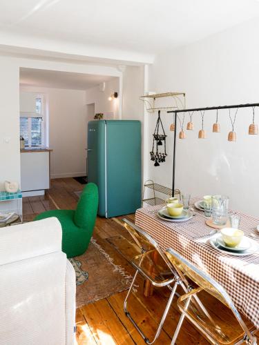 a living room with a table and a green refrigerator at Villa Robs - Appartements tout confort, TV connectée, Haut débit, Localisation idéale - Courts séjours & Affaires in Caen