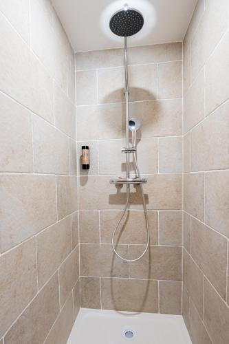a shower with a shower head in a bathroom at Villa Robs - Appartements tout confort, TV connectée, Haut débit, Localisation idéale - Courts séjours & Affaires in Caen