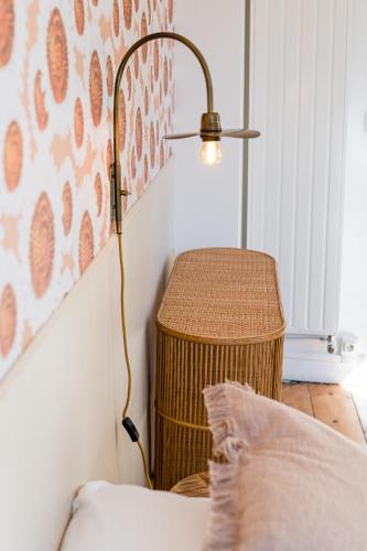 a lamp next to a wicker basket next to a bed at Villa Robs - Appartements tout confort, TV connectée, Haut débit, Localisation idéale - Courts séjours & Affaires in Caen