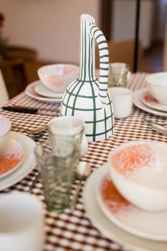 a table with plates and bowls and a vase on it at Villa Robs - Appartements tout confort, TV connectée, Haut débit, Localisation idéale - Courts séjours & Affaires in Caen