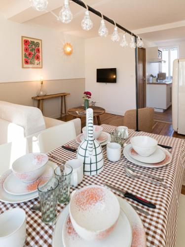 a dining room table with a red and white table cloth at Villa Robs - Appartements tout confort, TV connectée, Haut débit, Localisation idéale - Courts séjours & Affaires in Caen