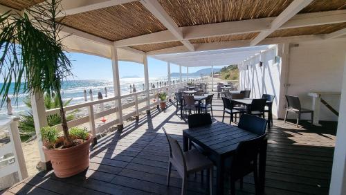 a patio with tables and chairs and a view of the beach at CAMERETTA SUL MARE con OMBRELLONE in Lido Di Fondi