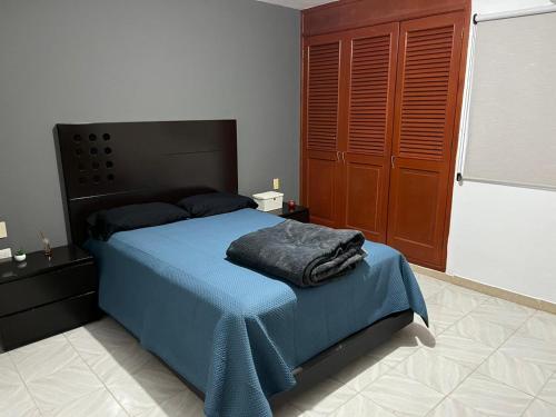 a bedroom with a bed with a blue blanket on it at Disfruta Boca del Rio in Boca del Río