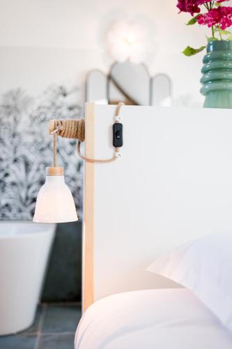 a bedroom with a bed and a lamp at Villa Robs - Appartements tout confort, TV connectée, Haut débit, Localisation idéale - Courts séjours & Affaires in Caen