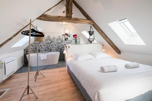 a attic bedroom with two beds and a bathtub at Villa Robs - Appartements tout confort, TV connectée, Haut débit, Localisation idéale - Courts séjours & Affaires in Caen