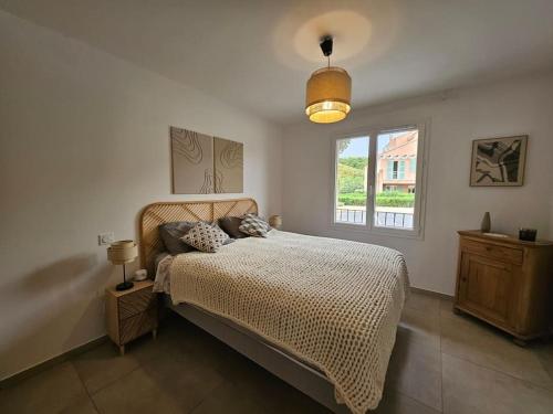 a bedroom with a large bed and a window at Appartement Chez Emma, le luxe en Bord de Mer by Monarca in Saint-Florent