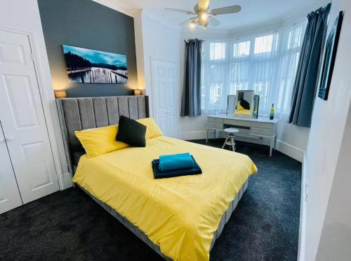 a bedroom with a yellow bed with a blue pillow on it at Flat in the heart of Leigh on Sea less than 2 miles from the beach in Southend-on-Sea