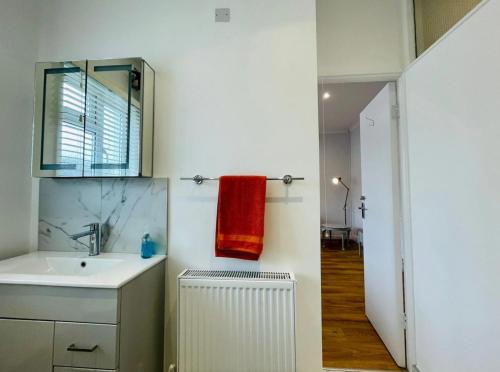 a bathroom with a sink and a red towel at Flat in the heart of Leigh on Sea less than 2 miles from the beach in Southend-on-Sea