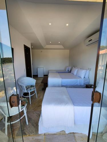 a hotel room with two beds and a window at Pousada Dreamland Buzios in Búzios