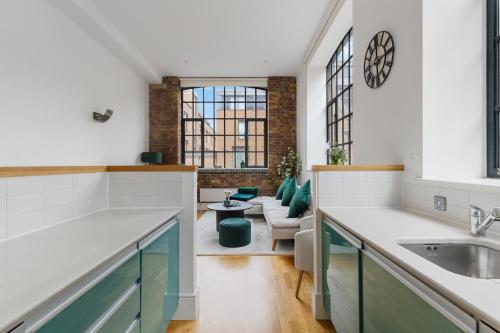 a kitchen with a sink and a living room at Central London, Kings Cross, Minutes From Station! in London