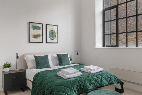 a bedroom with a bed with green and white sheets at Central London, Kings Cross, Minutes From Station! in London