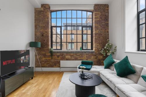 a living room with a couch and a tv at Central London, Kings Cross, Minutes From Station! in London