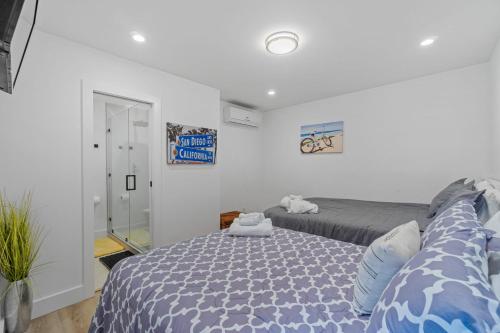 a bedroom with a bed with a blue comforter at Private Beachside Home with HotTub in Carlsbad