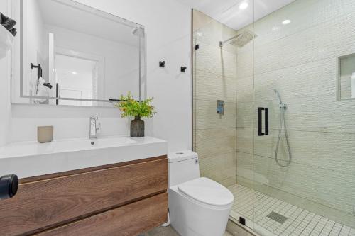 a bathroom with a toilet and a glass shower at Private Beachside Home with HotTub in Carlsbad