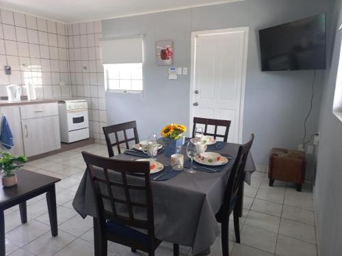 a dining room with a table and chairs and a kitchen at Grateful Corner Apartment Curaçao in Willemstad