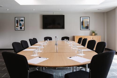 a conference room with a large wooden table and chairs at voco Belfast by IHG in Belfast
