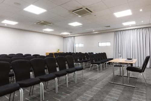 a conference room with black chairs and a white wall at voco Belfast by IHG in Belfast